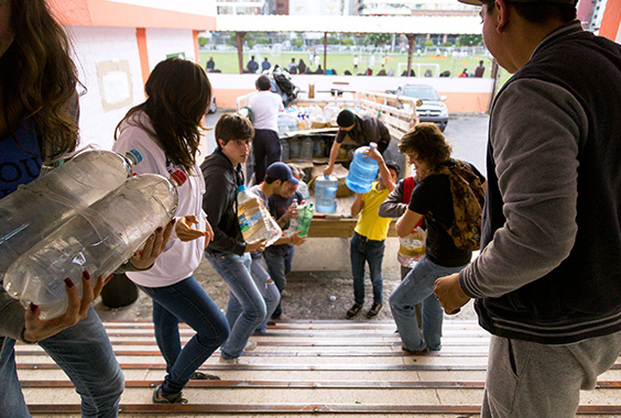 Voluntarios reciben donaciones de la sociedad civil en el centro de acopio que se instaló en el Colegio Benalcázar de Quito. Foto: Comparte Ecuador